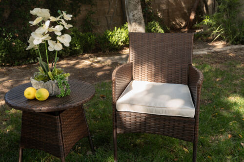 Wicker rattan chairs with soft seat cushions.