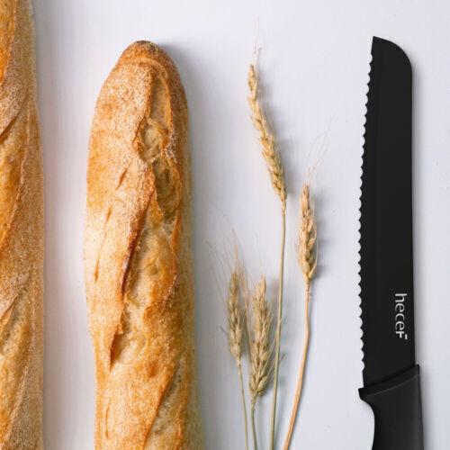 Bread knife next to bread and wheat stem. 